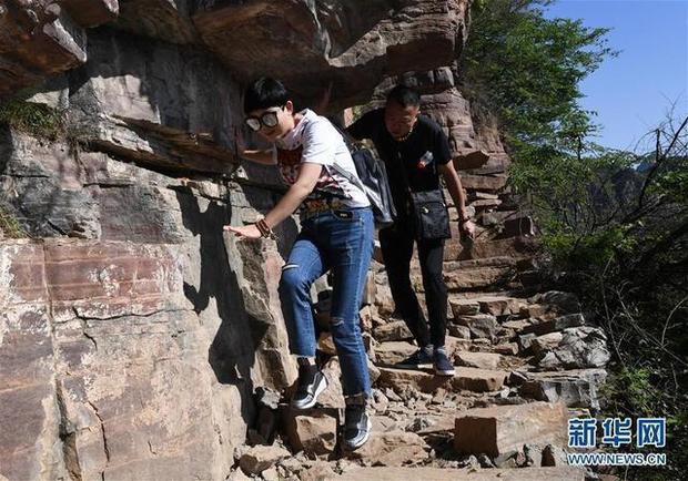 两位游客在郭亮村天梯景点体验步道的险峻(5月17日摄).