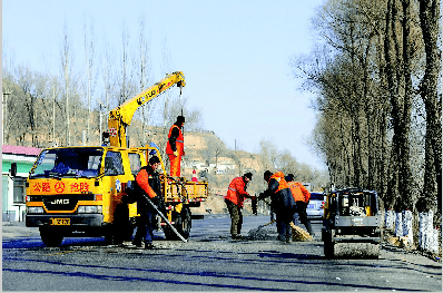 公路养护工人冒着严寒对209国道进行维修,确保境内群众出行顺畅