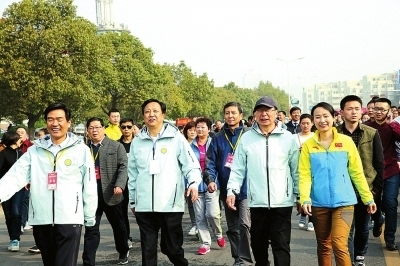 中国登山协会主席李致新(右三)向新县副县长臧曼(左三)传递全国群众