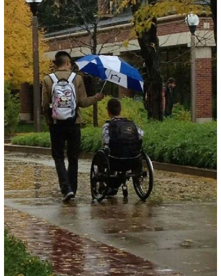 1. 一个男孩为他残疾的同学在雨天打伞.