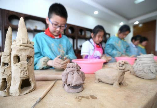 图为学生在体验陶艺制作.