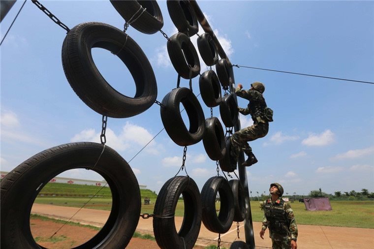 5月17日,新兵马平(上)在进行300米障碍训练.