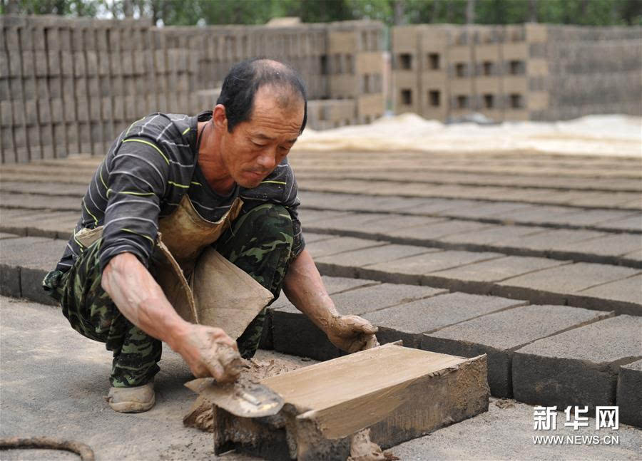 5月23日,任丘市出岸镇古建砖厂工人在制坯.新华社发(苑立伟 摄)