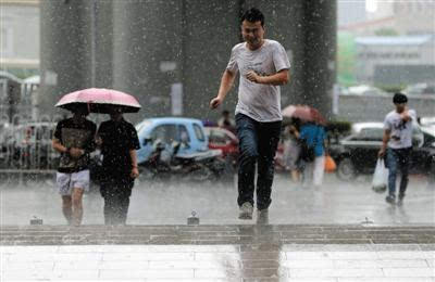 昨日,十里河,一场暴雨突然来袭,没带伞的路人在雨中奔跑.