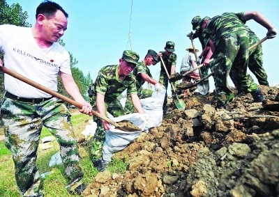 昨天,武汉市蔡甸区洪北大堤上,左少平(左一)和儿子左文豪(左二)并肩