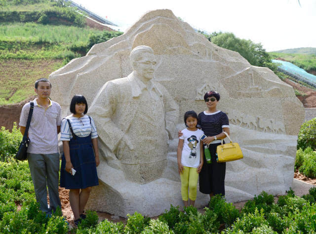 7月17日,白鹿原影视城内,游客在著名作家李若冰的雕塑前合影留念.