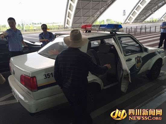 图为王伦军及其父亲正准备坐上早已等待在此的警车