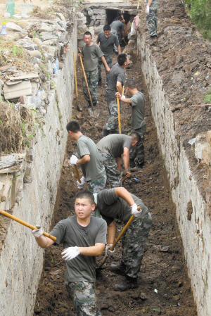 在井陉南关村,部队官兵正在清理排污渠.