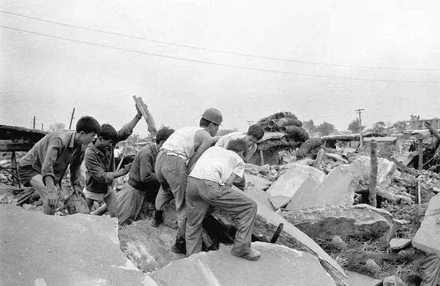 1976年7月,唐山大地震后,人们在清理废墟.视觉中国