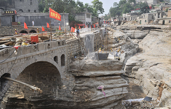 8月2日,在河北井陉县南峪镇台头村,交通部门正在抢修一座桥梁,桥下是