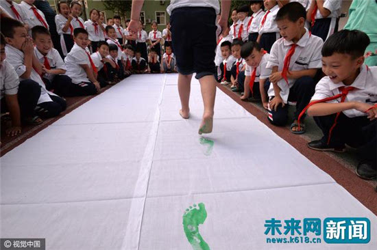 邯郸小学生用"绿脚丫"倡议"世界无车日"活动