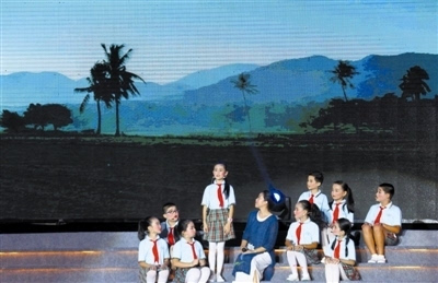三亚市第七小学师生在舞台上讲述《乡愁》.