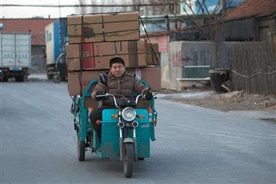 山东滨州淘宝村.30岁的快递员高鑫骑着电动三轮车在送货的路上.