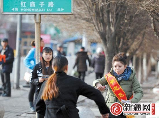 12月5日,在沙依巴克区红庙子路,志愿者劝导行人文明出行.