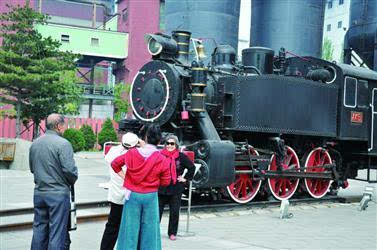 鞍钢展览馆门前的蒸汽式火车头吸引游客参观.
