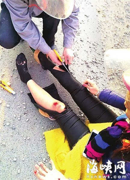 热心人帮摔倒的女骑手剪开裤管,便于包扎伤口