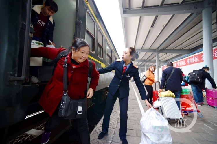 k4186次外来务工人员专列乘务员黄慧欣在四川渠县火车站帮助乘客下车