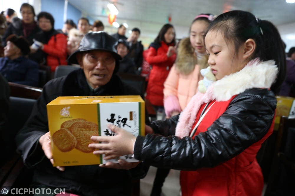 2月9日,一名小学生在向敬老院老人赠送元宵礼品.cicphoto/吴大庆 摄