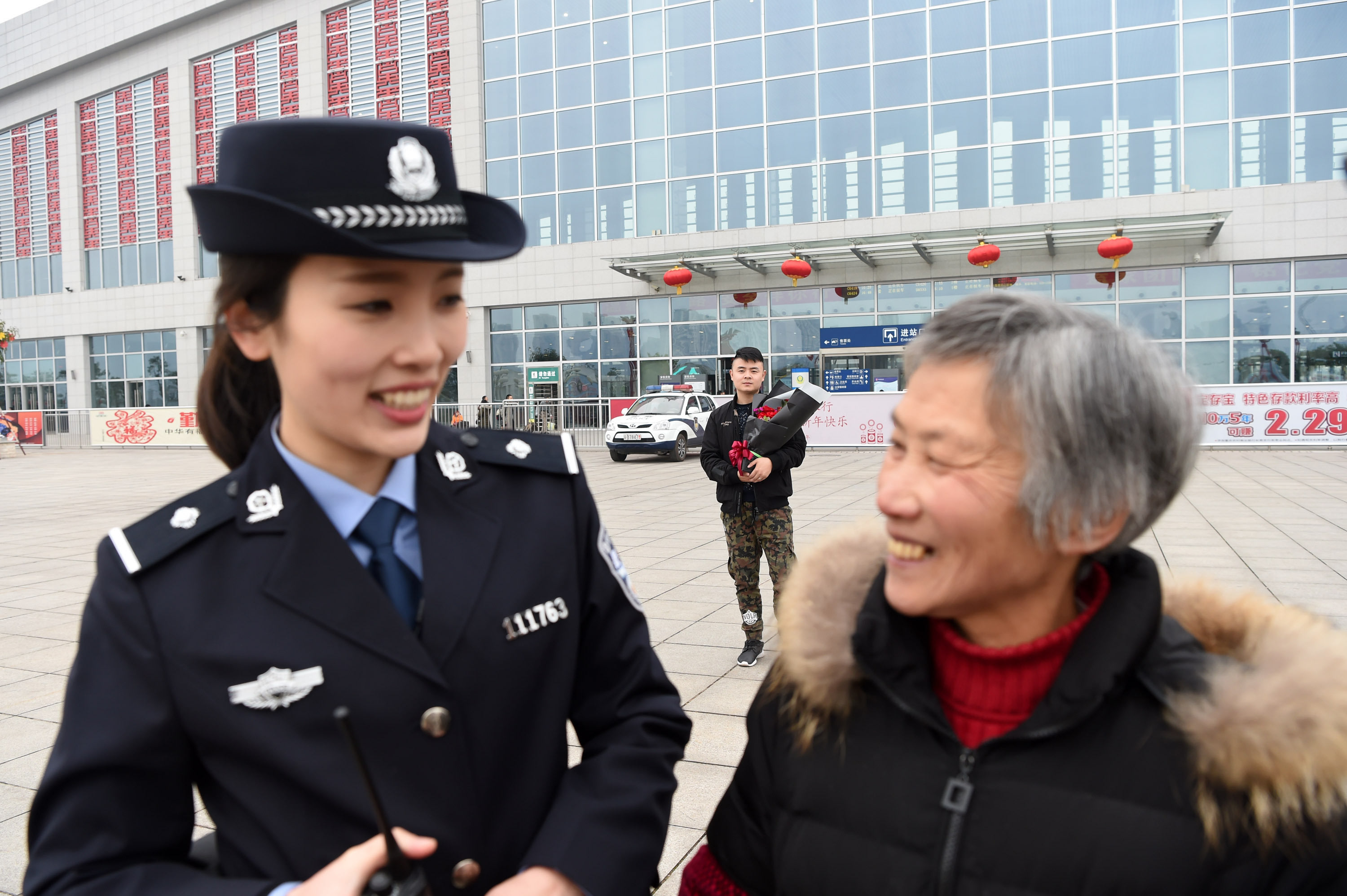 2月13日,饶雨欣(前左)在渝万高铁长寿北站工作,她的丈夫吴大希手捧