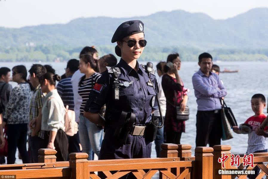 断桥上,身着统一制服的美女城管成为人海中的一道风景.