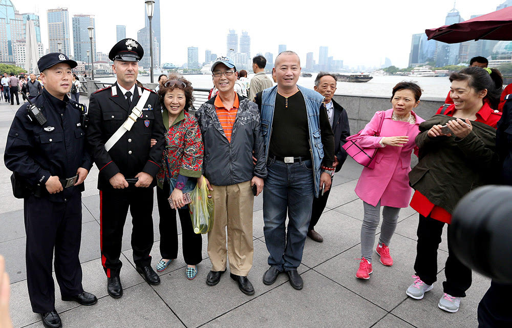 5月2日,中意警员在上海外滩与游客合影.