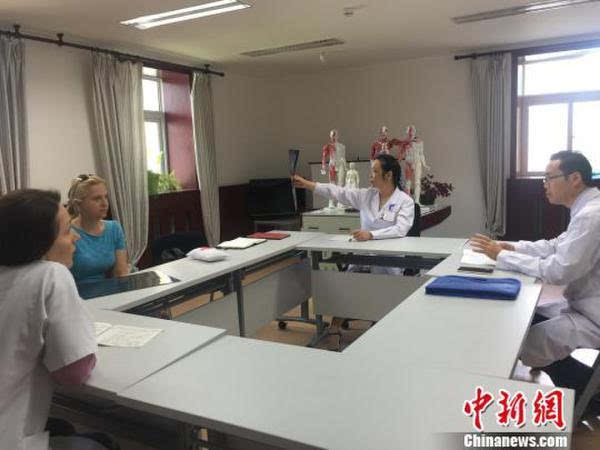 图为摩尔多瓦岐黄中医学院,中国中医和外方医生共同为患者会诊.