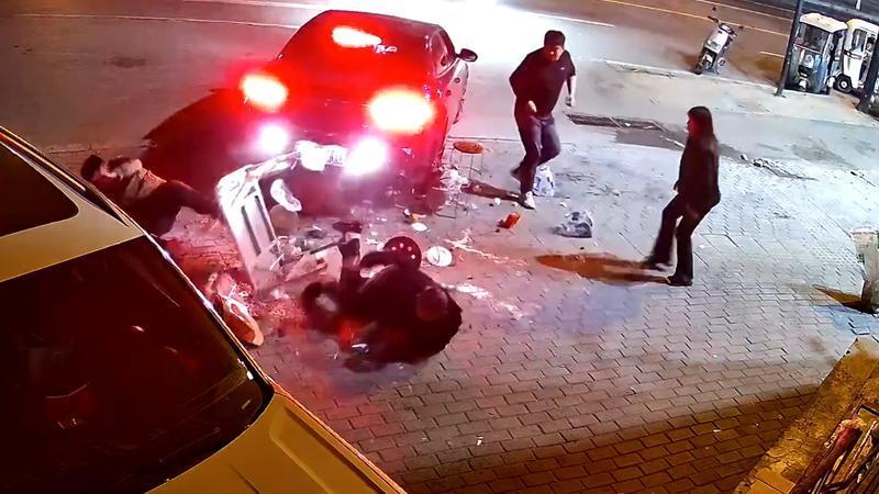 3男子正在路边吃饭，一路过车辆先停车后突然倒车，将桌子撞翻后开车扬长而去