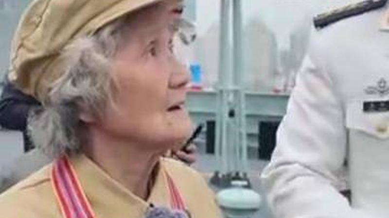 北部战区海军舰艇开放活动上，92岁抗美援朝女战士穿军装登舰，听着讲解抬头注视舰炮愣神数秒，站在甲板上不愿挪动脚步