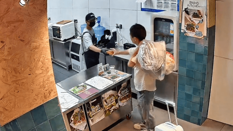 男子拖着掉轮的行李箱走进面包店，连要了8杯水，店员察觉反常主动递上面包