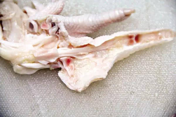5,刀口平行地放在鸡爪内侧,沿着骨头切入,剔掉爪趾骨,注意取出的骨头