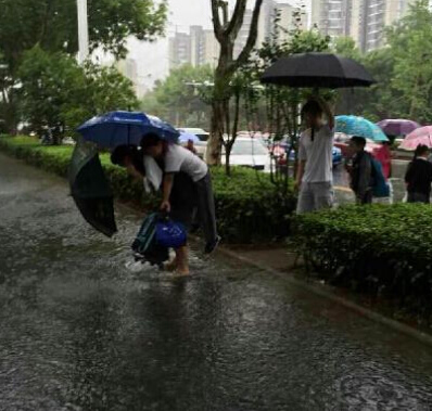 南京暴雨积水 老师背学生趟水进校