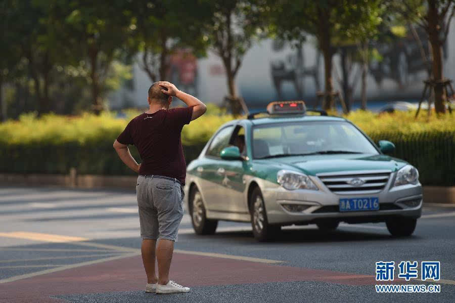 9月16日,乘客在杭州市区路边等待出租车.新华社记者 黄宗治 摄