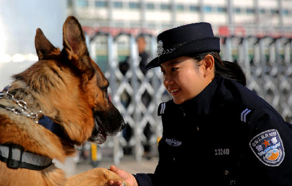 年轻女特警队员在休息时间与警犬说起了"悄悄话.