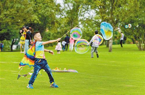 10月2日,两江新区中央公园,小朋友在公园里的阳光大草坪上玩耍.
