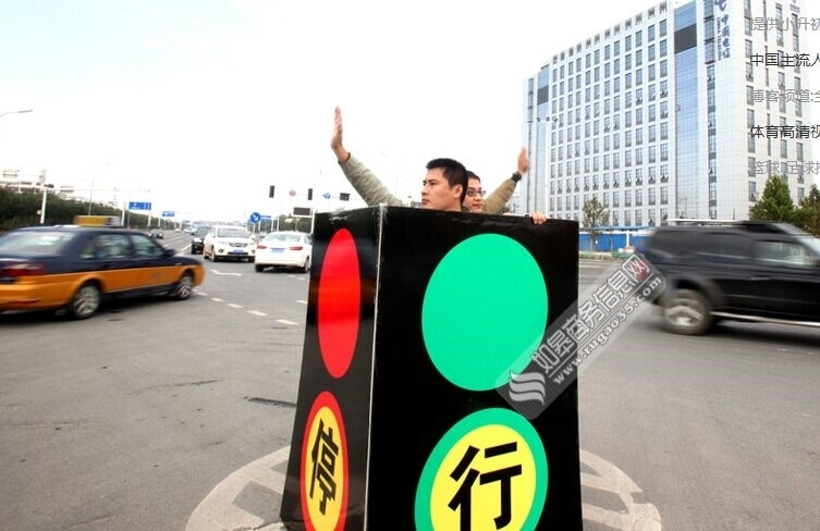 石家庄街头现人体红绿灯 两男子站箱子里指挥交通