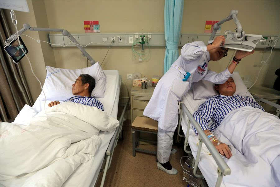 在浙江温州医科大学附属第一医院住院治疗的患者在病床上学习使用平板