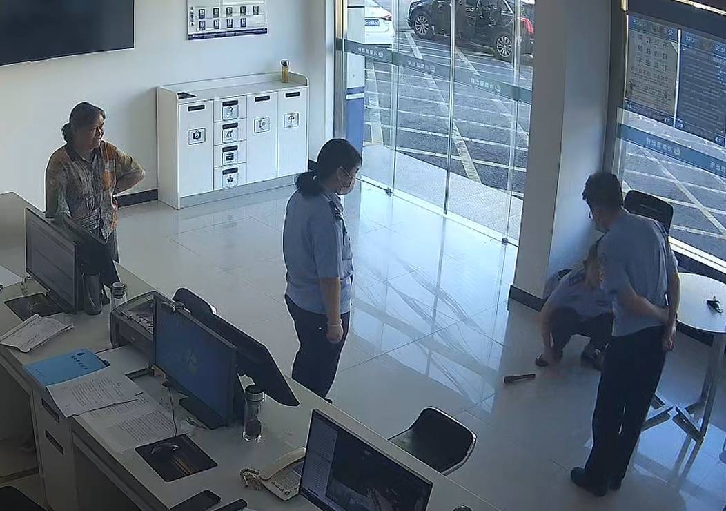 村民李大妈单手拿着一枚手榴弹，走进派出所值班大厅