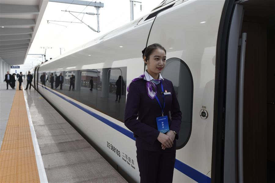 12月15日,一位乘务员站在金温铁路永康南站的动车组列车旁