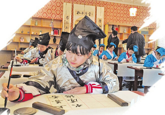 章丘首家"孔子学堂"开课,学生们在练习书法.