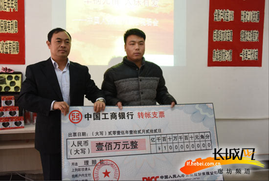 陈宝顺(左)与王女士的儿子(右)进行100万理赔款支票交接长城网廊坊12