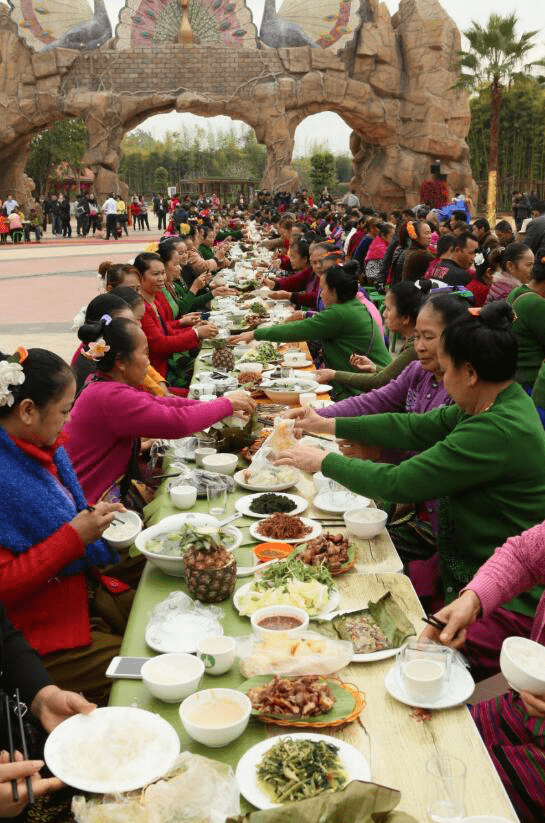 美酒金杯满,佳肴纵横陈,身着具有民族特色服饰的傣族及佤族舞者,打起