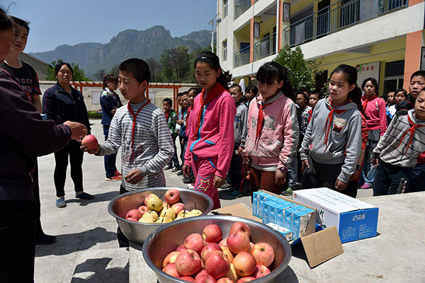 在山西省平顺县芣兰岩寄宿制小学,生活管理员在给学生们发水果