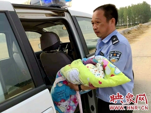 民警将弃婴抱上车