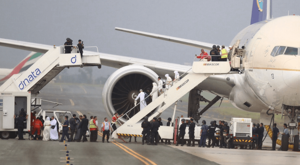 在菲律宾马尼拉国际机场,乘客从一架沙特阿拉伯航空公司的飞机上撤离