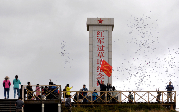 途经红原日干乔大草原,在红军过草地纪念碑前,队员们抛洒龙达缅怀先烈