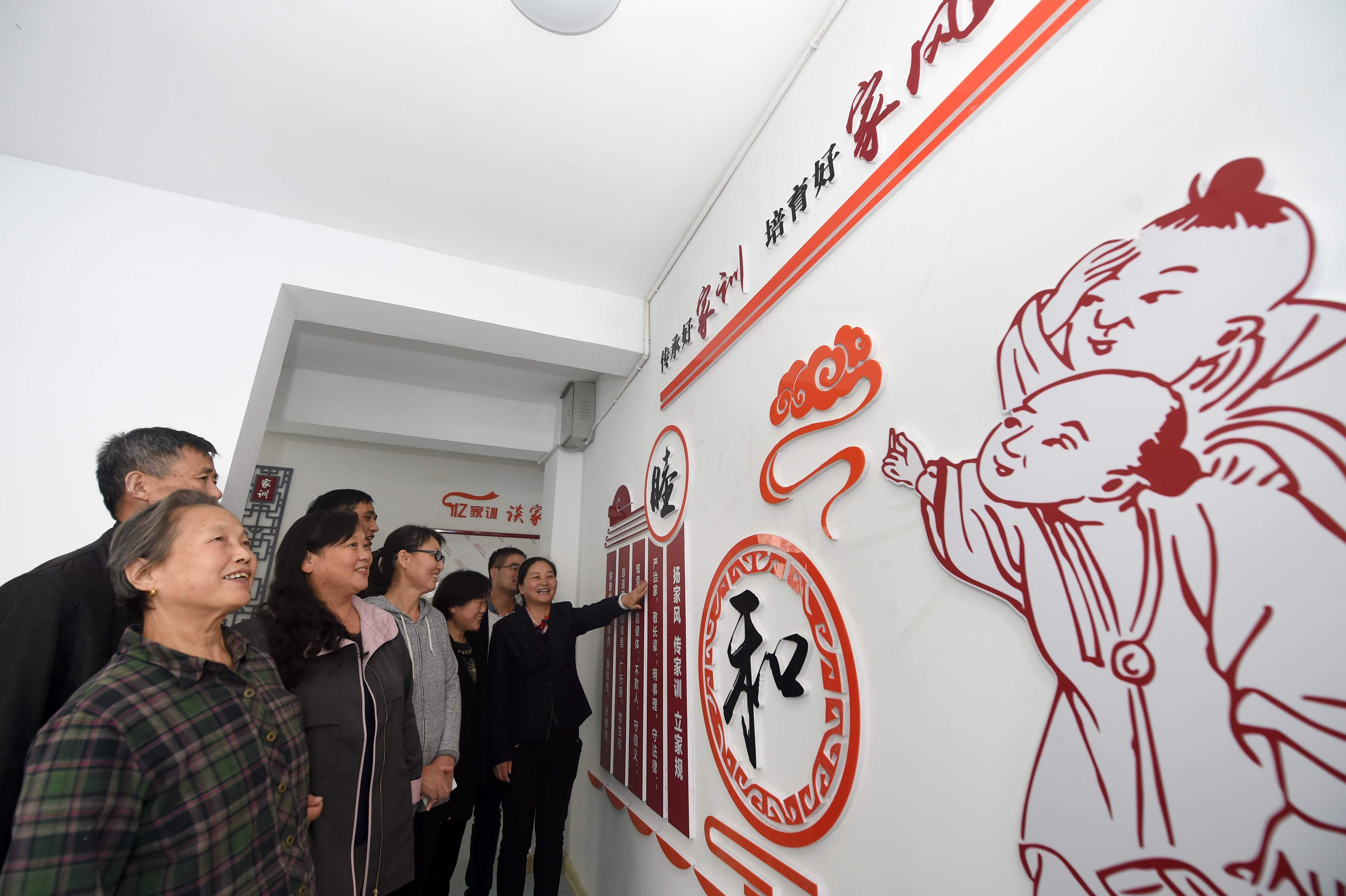 社区工作人员在向居民宣传讲解家风家训等内容.