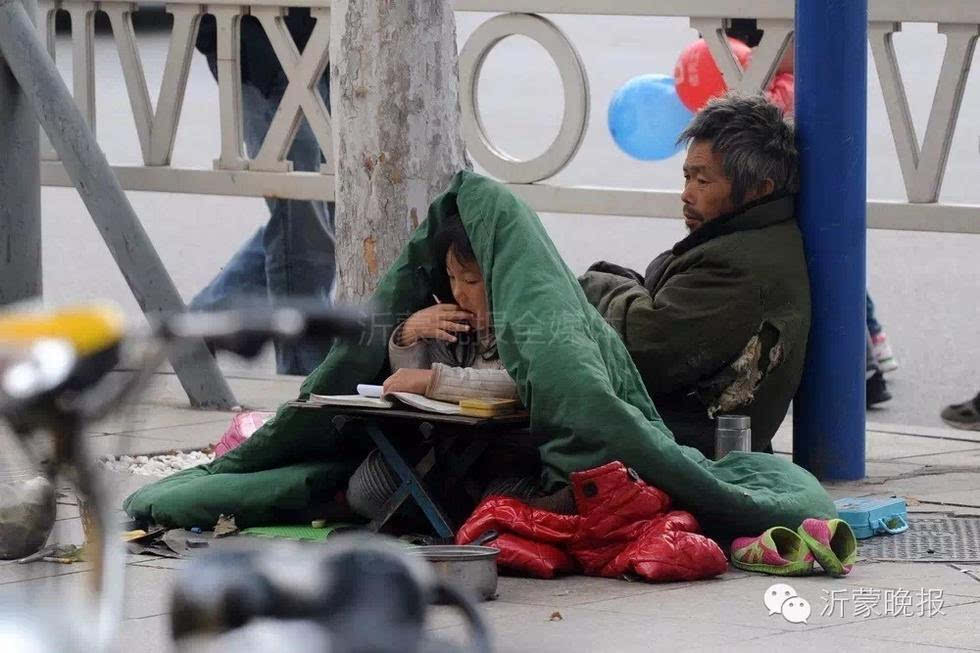 他的家人在一旁乞讨.