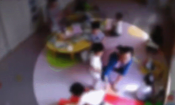 园的监控显示,一名老师把一个两岁的女孩拽到身旁,用手掐住孩子的脸