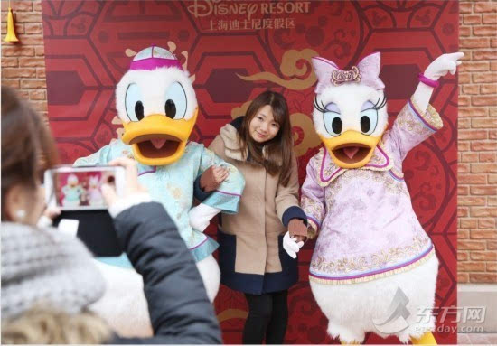 市民游客与身着唐装的唐老鸭合影留念.