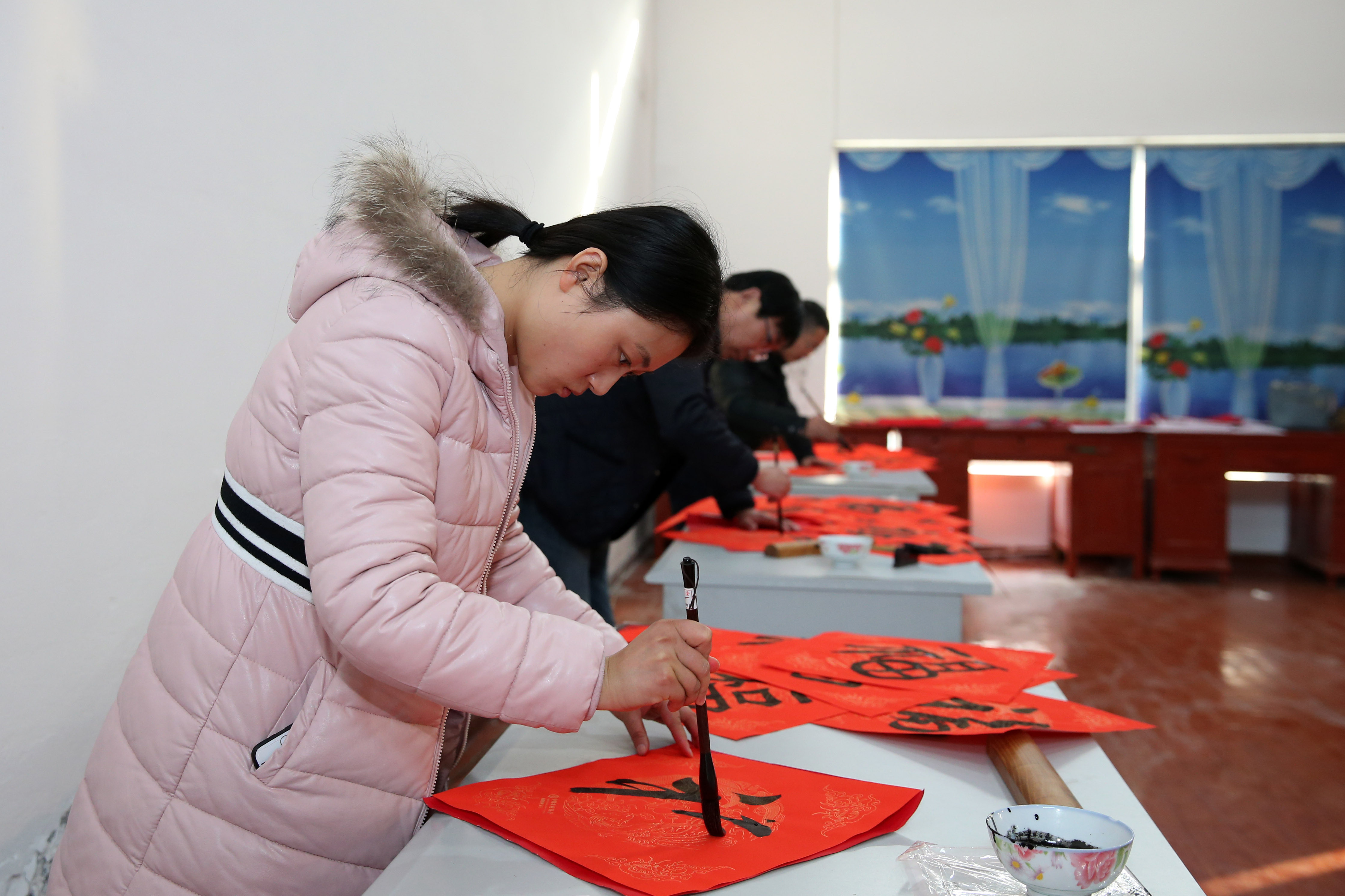 1月13日,几名当地书法爱好者为村民和老人书写福字.